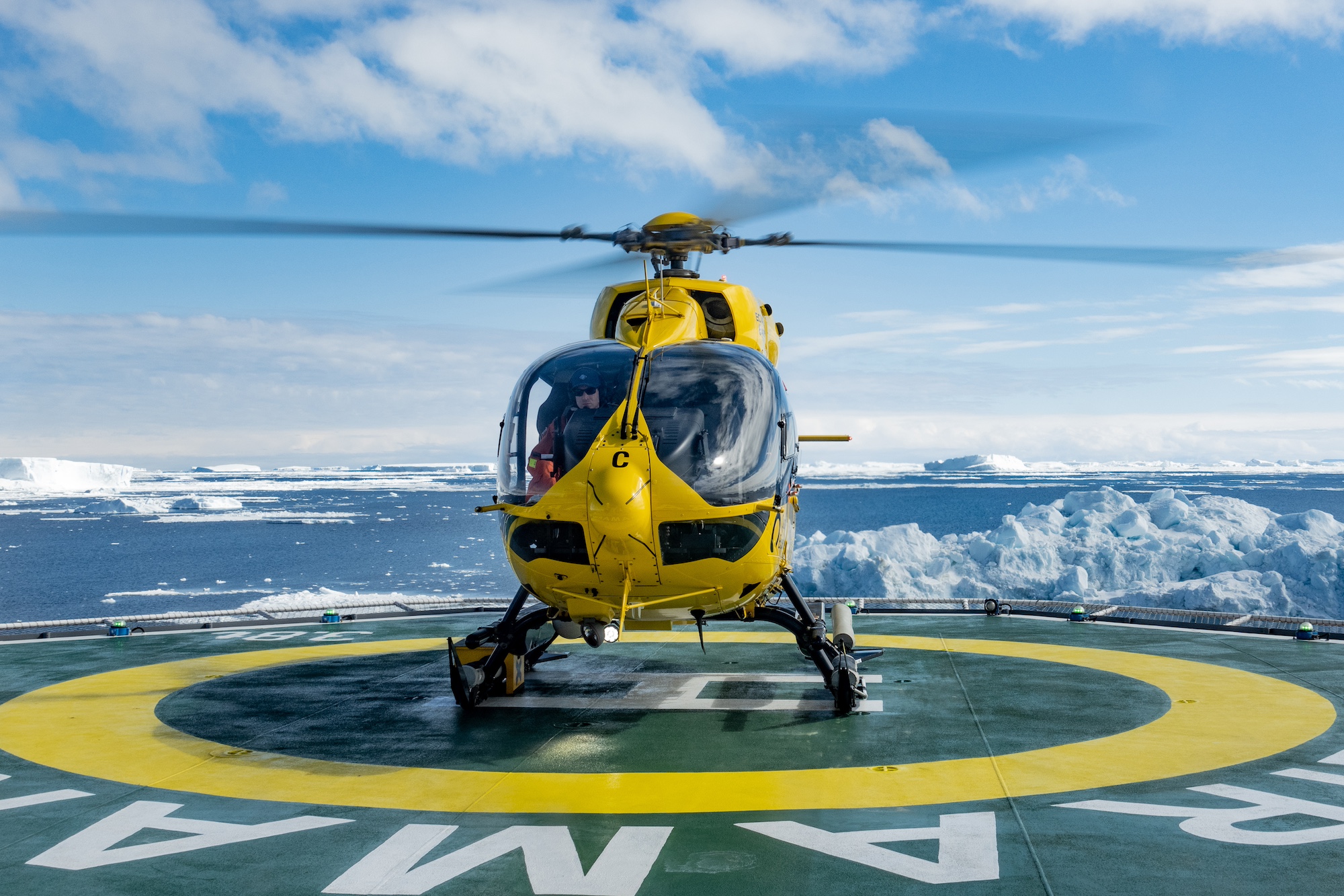 A helicopter takes off from a helipad on board a ship in Antarctica