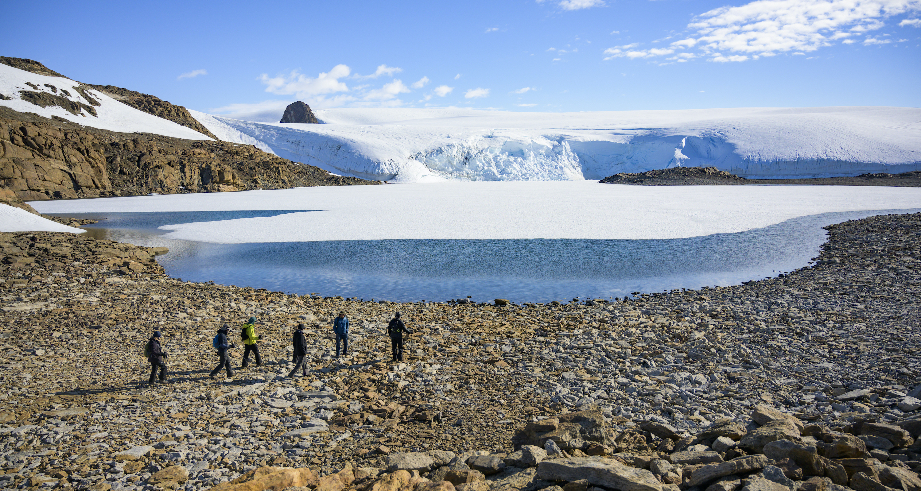 Hikers at a glacial lake in the Antarctic interior