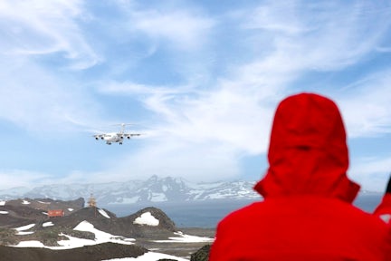 A guest watches as a plane comes in to land on King George Island